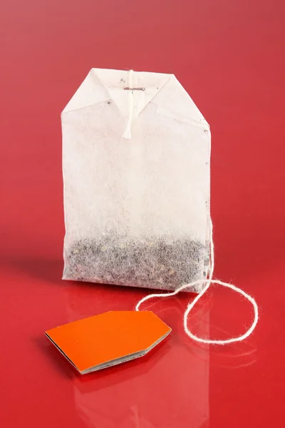 Tea bag, piros háttér — Stock Fotó