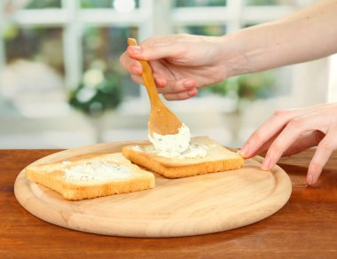 Salam hazırlama süreci parlak zemin üzerine kavrulmuş ekmek rulo: el smear krem peynirli kızarmış ekmek üzerinde