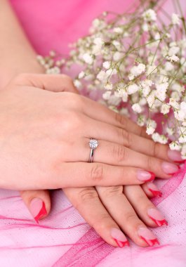 el ve halka ve pembe bir arka plan üzerinde çiçekler