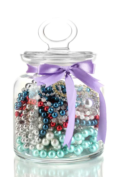 Vaso di vetro contenente varie perle isolate su bianco — Foto Stock
