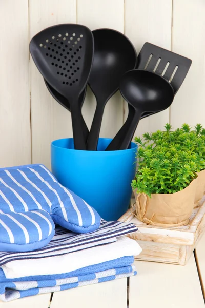 Ajustes de cocina: utensilios, agarraderas, toallas y más en la mesa de madera —  Fotos de Stock