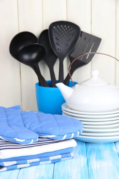 Configurações da cozinha: utensílio, pegadores de panela, toalhas e muito mais na mesa de madeira — Fotografia de Stock