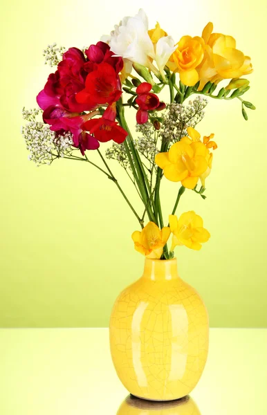 Beau bouquet de freesia en vase sur fond vert — Photo