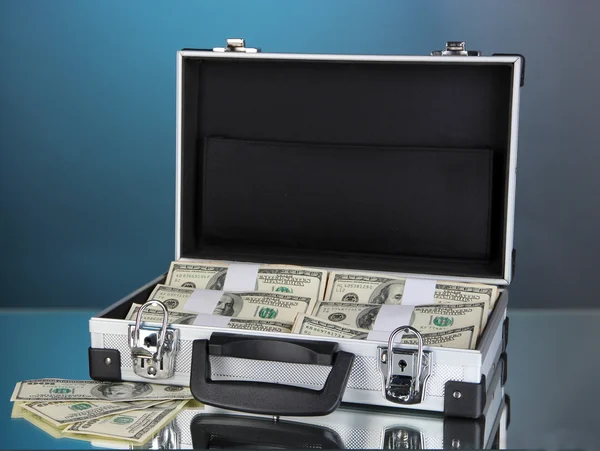 青色の背景に 100 ドル紙幣のスーツケース — ストック写真