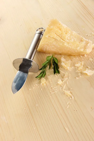 Piece of Parmesan cheese with knife on wooden table close-up — Stock Photo, Image