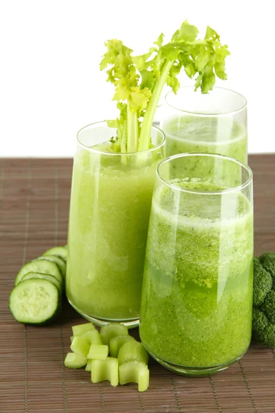 Verres de jus de légumes verts sur tapis de bambou, isolés sur blanc — Photo