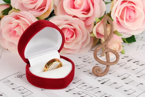 Clave triple, rosas y caja con anillo de boda sobre fondo musical —  Fotos de Stock