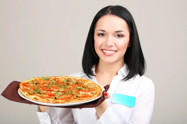 Красивая девушка официант с пиццей изолированы на белом — стоковое фото