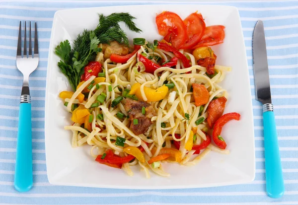 Noodles with vegetables on plate on napkin — Stock Photo, Image