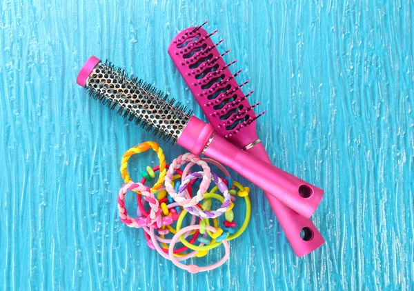 Scrunchies, hairbrush and hair - clip on a blue background — Stock Photo, Image