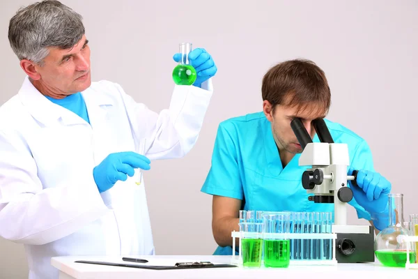 Médico y ensayador durante la investigación sobre el fondo de la habitación — Foto de Stock