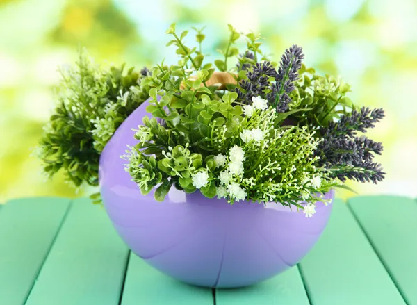Горшок с цветами на деревянном столе на фоне природы — стоковое фото