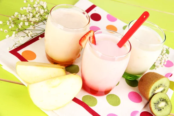 Deliciosos yogures con frutas en vasos sobre mesa de madera — Foto de Stock