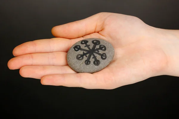 Wróżek z symboli na kamień w ręku na szarym tle — Zdjęcie stockowe