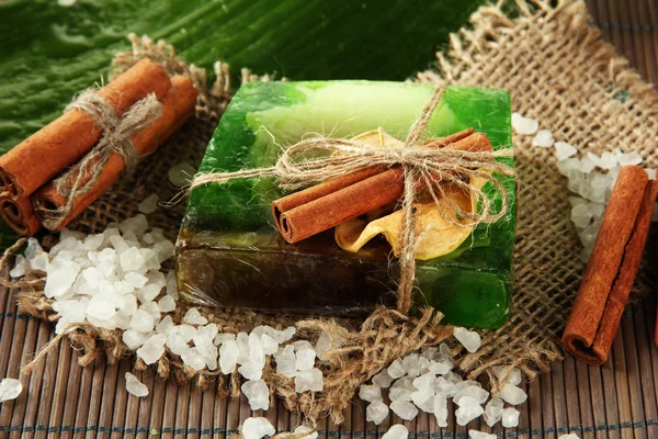 Hand-made soap, sea salt and leaf on grey bamboo mat — Stock Photo, Image