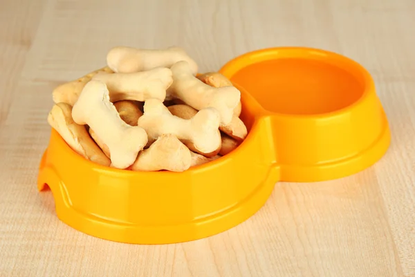 Comida seca para perros en un tazón sobre fondo de madera — Foto de Stock