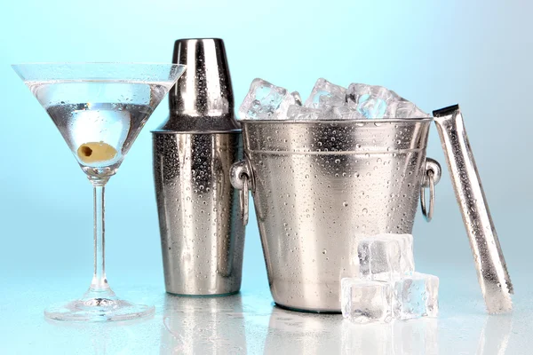 Cubo de hielo de metal y agitador y cóctel sobre fondo azul — Foto de Stock