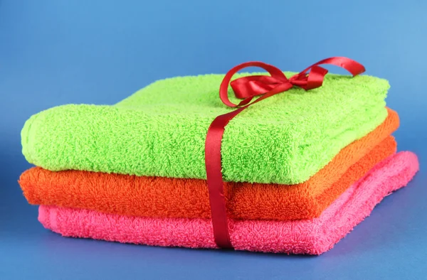 Towels tied with ribbon on blue background — Stock Photo, Image