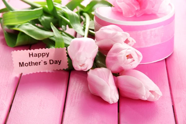 Mooi boeket van tulpen en gift voor Mother's Day op roze houten achtergrond — Stockfoto