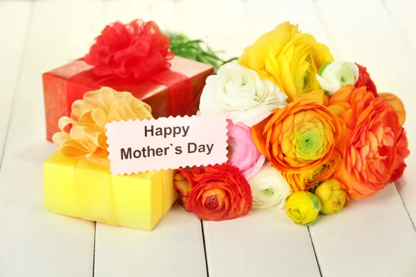 Ranunculus (buñuelos persas) y regalos para el día de las madres, sobre fondo de madera blanca — Foto de Stock