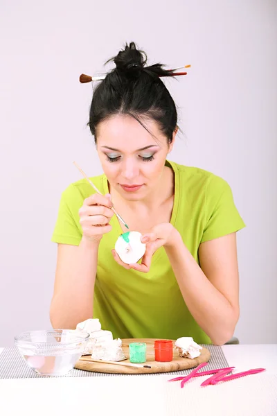 Young pretty woman working on clay sculpture, on gray background — Stock Photo, Image