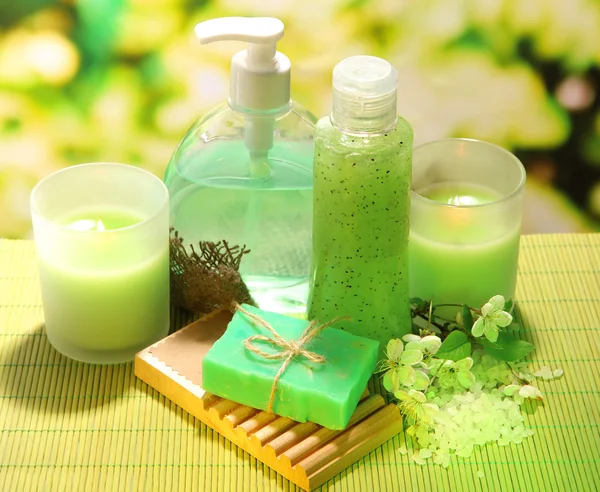 Cosmetics bottles and natural handmade soap on green background — Stock Photo, Image