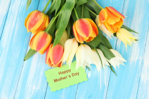 Beautiful white and orange tulips on color wooden background — Stock Photo, Image