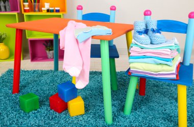 küçük ve renkli masa ve sandalyeler ile bebek giysileri