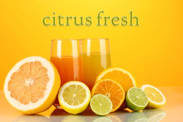 Viel reife Zitrusfrüchte mit Säften auf orangefarbenem Hintergrund — Stockfoto