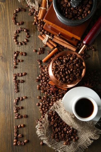 Cup of coffee, pot and grinder on wooden background — Stock Photo, Image