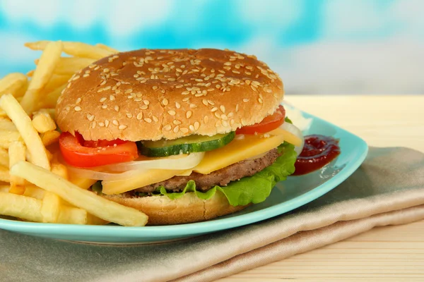 Savoureux cheeseburger aux pommes de terre frites, sur fond lumineux — Photo