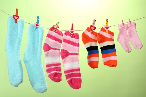 Bunte Socken hängen an der Wäscheleine, auf farbigem Hintergrund — Stockfoto