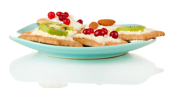 Gustose tartine con formaggio, kiwi e mirtillo, mandorle, su piastra colorata, isolate su bianco — Foto Stock