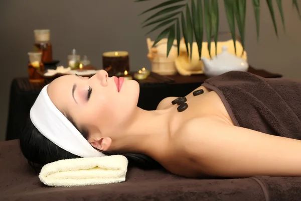 Belle jeune femme dans le salon de spa, sur fond sombre — Photo