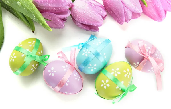 Světlé velikonoční vajíčka a tulipány, izolované na bílém — Stock fotografie