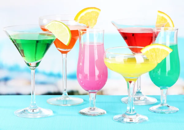 Brýle koktejlů na stole poblíž bazén — Stock fotografie