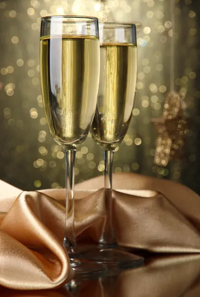 Zwei Gläser Champagner auf hellem Hintergrund mit Lichtern — Stockfoto