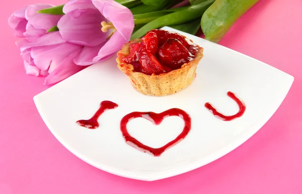 草莓和酱汁上颜色背景板上的甜蜜蛋糕 — 图库照片