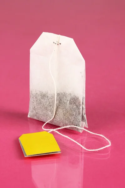 Пакет чая на розовом фоне — стоковое фото