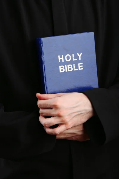 Sacerdote sosteniendo la sagrada Biblia, de cerca — Foto de Stock