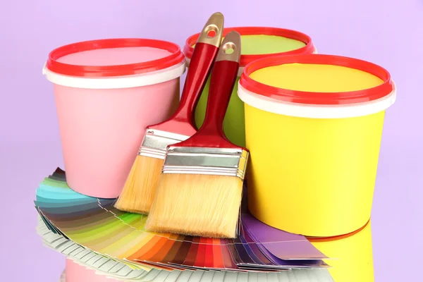 Set for painting: paint pots, brushes, palette of colors on lilac background — Stock Photo, Image