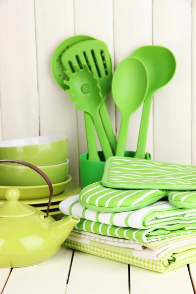 Kitchen settings: utensil, potholders, towels and else on wooden table — Stock Photo, Image