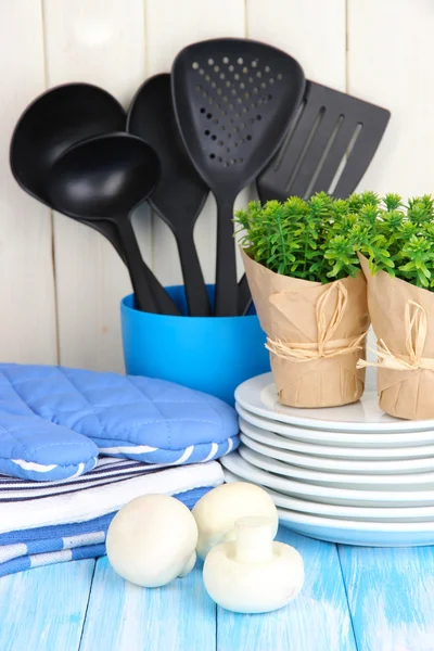 Ajustes de cocina: utensilios, agarraderas, toallas y más en la mesa de madera —  Fotos de Stock