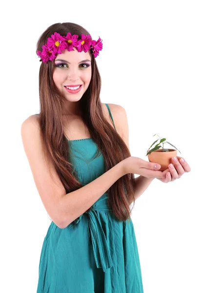 Menina bonita nova com grinalda decorativa em sua cabeça segurando panela com planta verde, isolado em branco — Fotografia de Stock