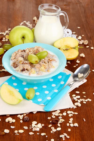 Farine d'avoine utile dans un bol avec des fruits sur une table en bois close-up — Photo