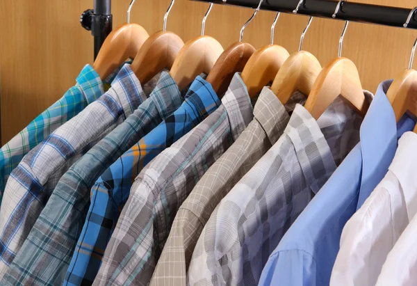 Мужские рубашки на вешалках в гардеробе — стоковое фото