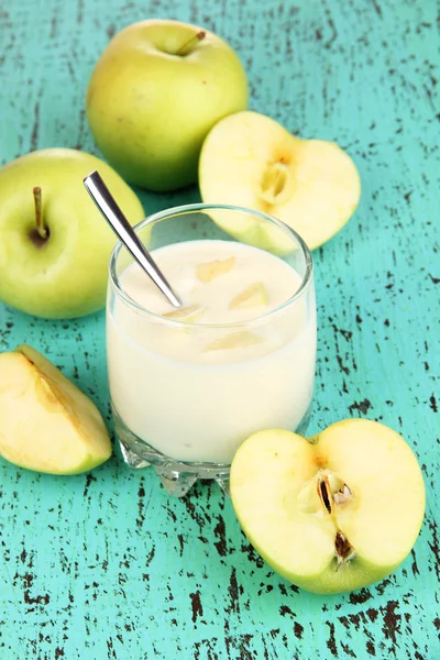Delicious yogurt in glass with apple on wooden table close-up — Stock Photo, Image