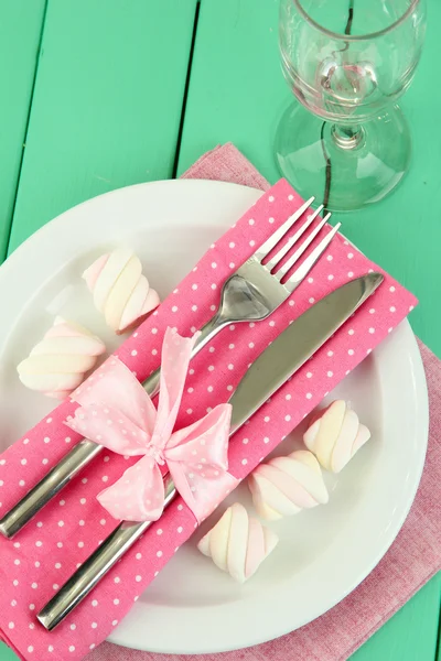 Tischdekoration in weißen und rosa Tönen auf farbigem Holzhintergrund — Stockfoto