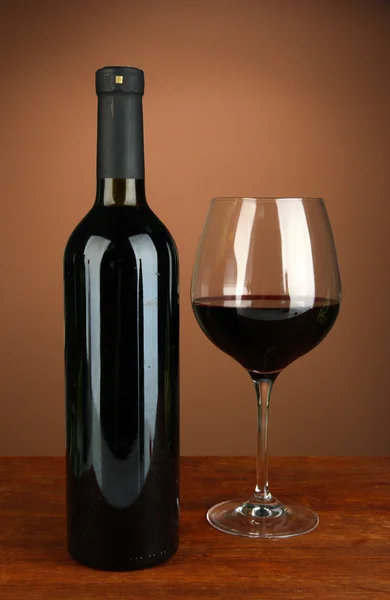 Composition of wine bottle and glass of red wine, on color background — Stock Photo, Image