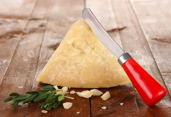 Pedazo de queso parmesano con cuchillo en la mesa de madera — Foto de Stock